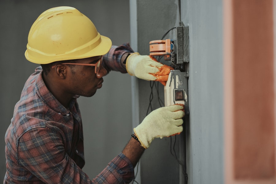 Technician in a hard hat working on a wall-mounted unit